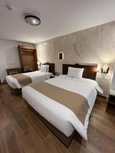 a hotel room with two large beds in it at Alpacaterra Machupichu Hotel in Machu Picchu
