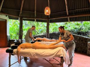two men and a woman laying on a bed at ALMAH GLAMPING in Cali
