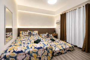 a bedroom with a bed with a colorful comforter at 2 Mins Away from Mactan Cebu Airport in Pusok +17 photos
