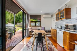 an open kitchen with a table and a patio at The Nest - Guest House, Acacia Bay, Panoramic Lake Views in Taupo