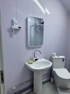 a white bathroom with a sink and a toilet at Mongolian traditional house Ger in Dzuunmod