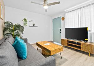 a living room with a couch and a flat screen tv at One Bed Honolulu Kaaha in Honolulu
