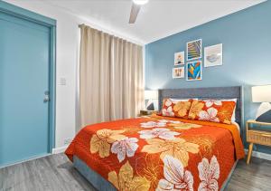 a bedroom with a bed with an orange bedspread at One Bed Honolulu Kaaha in Honolulu