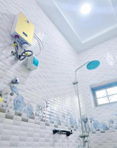 a bathroom with a shower with blue and white tiles at Fofana Luxury Suites in Sotuom +45 photos