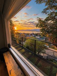a window with a view of a sunset at Balcón Austral beautiful apartment with incredible views of the mountains and the city in Ushuaia