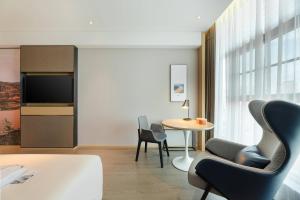 a living room with chairs and a table and a tv at Atour Hotel Yan'an Luyi Park in Yan'an