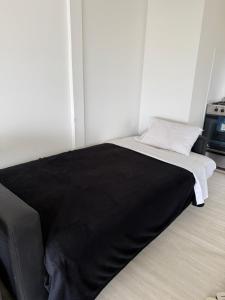 a bed in a room with a black blanket at Balcón Austral beautiful apartment with incredible views of the mountains and the city in Ushuaia