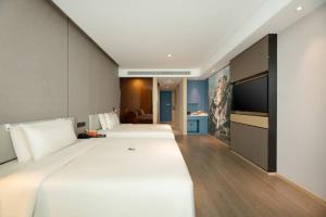 a hotel room with two beds and a flat screen tv at Atour Hotel Yan'an Luyi Park in Yan'an