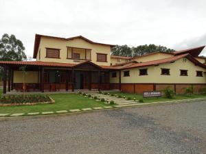 a house with a lawn in front of it at Hotel e Restaurante Sabor de Minas in Salinas