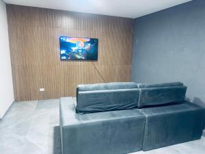 a leather couch in a room with a painting on the wall at Refúgio dos ventos in Campos do Jordão