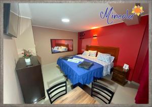 a bedroom with a bed and a table and chairs at Hostal Mineola Huacho in Santa María
