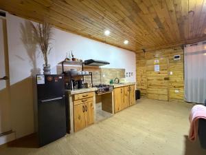 a kitchen with a black refrigerator and wooden cabinets at Carol Haus in Oxapampa