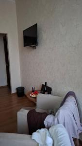 a living room with two white couches and a television at The Golden Street Hotel in Baku