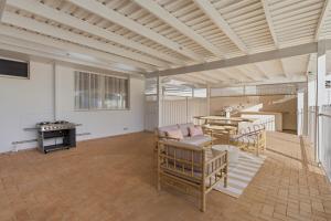 a large living room with a table and chairs at Mediterranean Beachside retreat with a pool in Broadwater