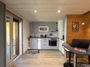 a kitchen with white appliances and a table with a laptop at Source Olympique Alpes in Gilly-sur-Isère
