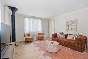 a living room with a couch and a tv at Mediterranean Beachside retreat with a pool in Broadwater