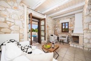 a living room with a stone wall at Villa Boscheto Tria in Agios Leon