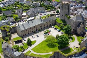 an aerial view of a castle with cars parked at L'Hostellerie du Château de Bricquebec in Bricquebec