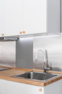 a stainless steel sink in a kitchen with white cabinets at Lumahaus Chamber Palaiologou in Thessaloniki +65 photos