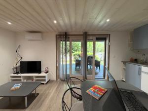 a living room with a table and a kitchen at Source Olympique Alpes in Gilly-sur-Isère