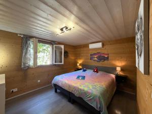 a bedroom with a bed in a wooden room at Source Olympique Alpes in Gilly-sur-Isère