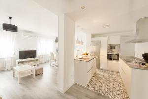 una cucina con elettrodomestici bianchi e un soggiorno di Apartamento Turístico la Concordia a Guadalajara