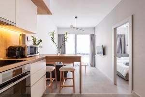 a kitchen and dining room with a table and a bed at Skg Cityscape Metropolis in Thessaloniki
