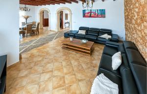 a living room with a black leather couch and a table at Sa Tanqueta De Calonge in Santanyi