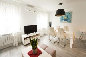 a white living room with a table and a television at Apartamento Turístico la Concordia in Guadalajara