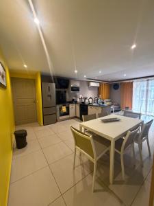 a kitchen and dining room with a table and chairs at AU BONHEUR DE PINPIN in Les Abymes