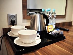 a counter with two cups and a coffee pot on it at Villa Masoneria in Łódź