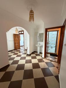 a room with a checkered floor and a doorway at Mira Guest House in Taghazout