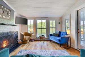 a living room with blue chairs and a fireplace at Heart's Desire, Cottage with stunning lake views in Effort