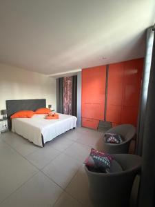 a bedroom with a white bed and red walls at AU BONHEUR DE PINPIN in Les Abymes