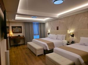 a hotel room with two beds and a table at Alpacaterra Machupichu Hotel in Machu Picchu