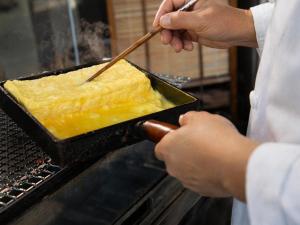 a chef is preparing a dish of food in an oven at Hotel Resol Hakodate in Hakodate