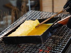 a person is cooking food on a grill at Hotel Resol Hakodate in Hakodate