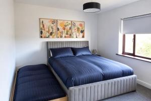 a bedroom with a bed with blue sheets and a window at Ardee Retreat - Sleeps 6, Garden, Walk to Town in Ardee