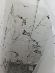 a bathroom with a marbleiled ceiling with a shower at ИНХаус Т in Cholpon-Ata