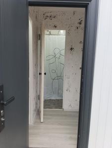 a mirror with a drawing of a man on a wall at ИНХаус Т in Cholpon-Ata