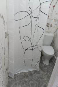 a shower curtain with a drawing of a woman in a bathroom at ИНХаус Т in Cholpon-Ata