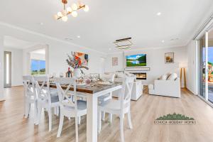ein weißes Esszimmer mit einem weißen Tisch und Stühlen in der Unterkunft Riverside Meadows in Echuca