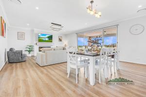 ein Esszimmer und ein Wohnzimmer mit Tisch und Stühlen in der Unterkunft Riverside Meadows in Echuca