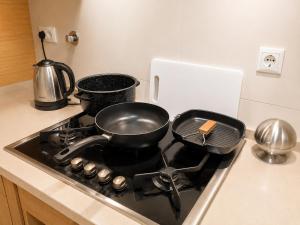 a stove top with two pots and pans on it at Bom dia Parque Nações LisboaZ in Lisbon +21 photos
