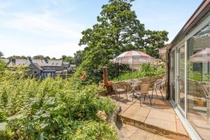 a garden with a patio with a table and chairs at 3 Bed in Bakewell oc-96293 in Baslow
