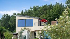 a house with a large window and a red umbrella at That Day's Namhae Ocean View Pension in Namhae
