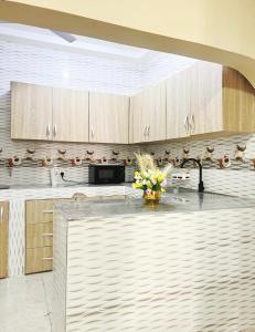 a kitchen with wooden cabinets and a sink at Fofana Luxury Suites in Sotuom