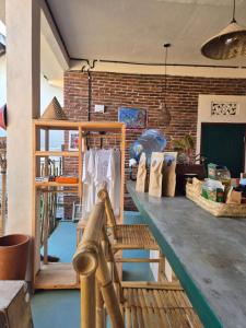 a room with a table and a brick wall at pesisircottage & stay in Selong Belanak