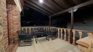 a balcony with chairs and a table on a brick wall at Archontiko Chios Traditional Mansion in Thymianá