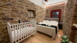 a bedroom with two beds and a brick wall at Archontiko Chios Traditional Mansion in Thymianá